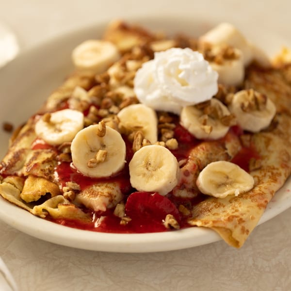 A Louie's Waffle House crepe with bananas, walnuts, strawberry sauce, and whipped cream.
