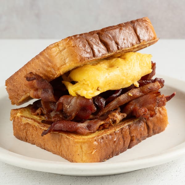 Louie's Waffle House breakfast sandwich with scrambled eggs and bacon on thick French toast.